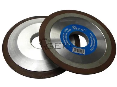 Two grinding wheels are shown against a white background. One wheel is in focus and has a blue label with text and a barcode.