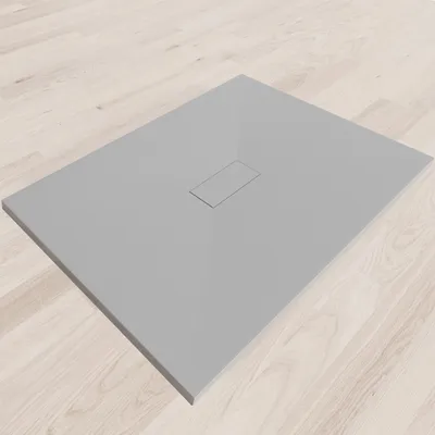 A flat, gray shower tray with a central drain cover, placed on a light wooden floor.