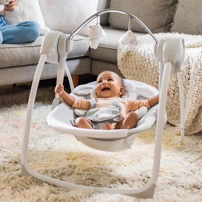 Produktbild von INGENUITY Babywippe, faltbar, elektrisch – Motiv: Kleines Schaf – mit abnehmbarem Bogen und Spielzeug. Timer-Einstellungen. Schaukelfunktion.