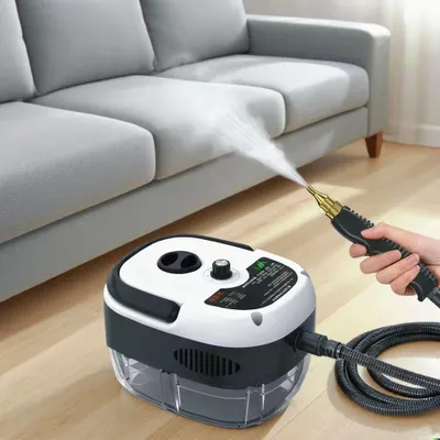 A person is using a steam cleaner to clean a gray sofa.
