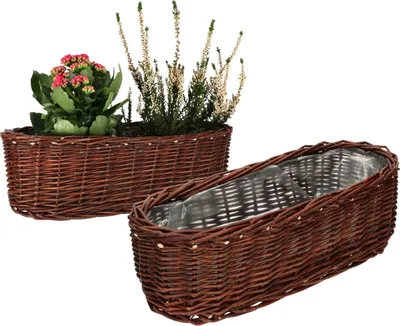 Two oval wicker planters, one filled with plants and flowers, the other empty and lined with plastic.