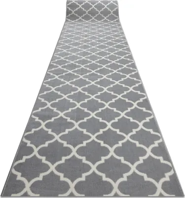 A long runner rug with a geometric pattern is laid out on a white background.