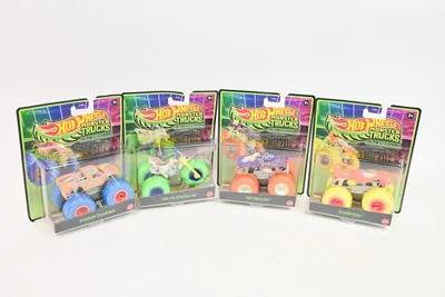 Four Hot Wheels Monster Trucks in their packaging, arranged in a row against a white background.