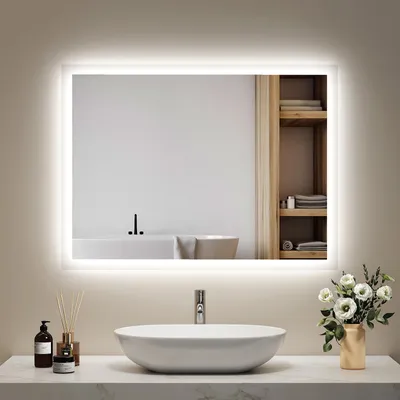 A bathroom vanity with a sink and a lighted mirror.