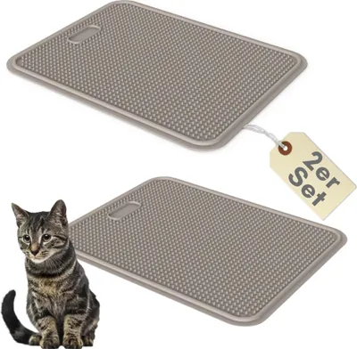 Two gray cat litter mats are shown, with one mat having a tag attached. A tabby cat is sitting in the foreground next to the bottom mat.