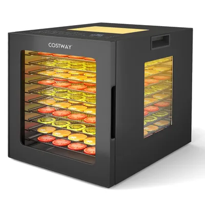 A black food dehydrator with multiple trays filled with sliced fruits and vegetables, illuminated from within.