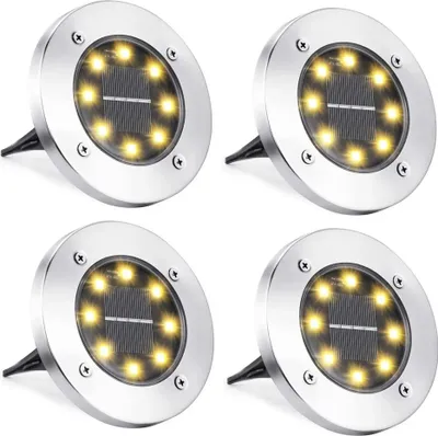 Four solar-powered ground lights arranged in a grid.