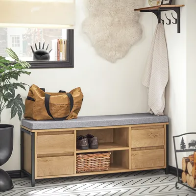 An entryway with a shoe bench, storage, and decorative items.