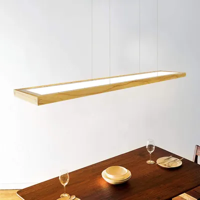 A wooden LED pendant light hangs above a dining table set for a meal.