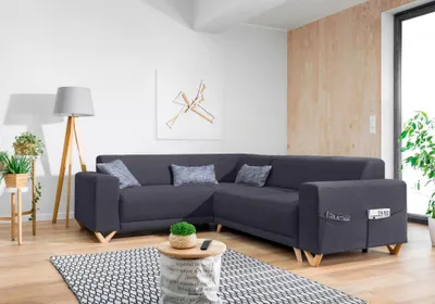 A modern living room with a dark gray sectional sofa, a floor lamp, and a small coffee table.