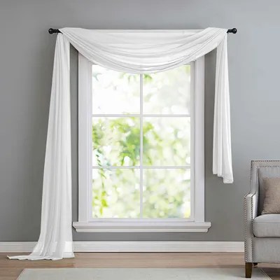 A white sheer fabric scarf draped over a window.
