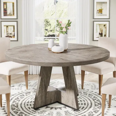 A round dining table with chairs in a dining room setting.