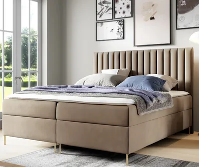 A bedroom scene with a large bed, window, and artwork on the wall.