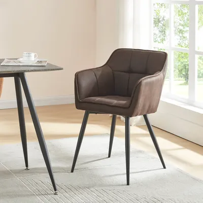 A brown upholstered dining chair with black metal legs sits next to a table in a well-lit room with a window.