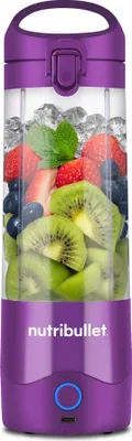 A purple and clear portable blender filled with ice and fruit.