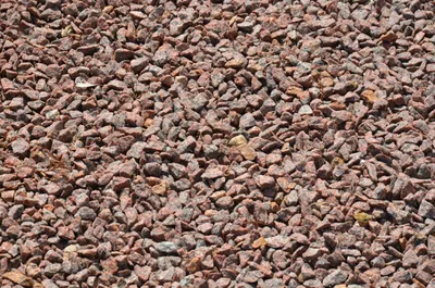A close-up, overhead view of red granite gravel.