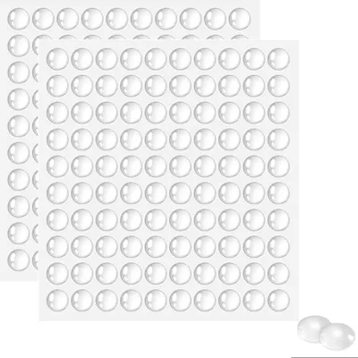 Two sheets of transparent, circular adhesive pads are shown against a white background. Three individual pads are also shown in the foreground.