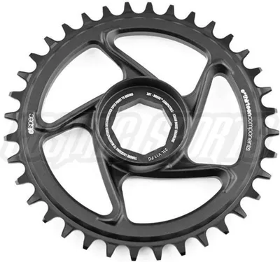 A black bicycle chainring is shown against a white background. The chainring has a complex, multi-spoke design with a central mounting hub. Text and logos are visible on the product itself.