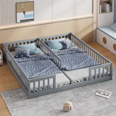 Two children's beds are set up in a room with bedding and pillows.