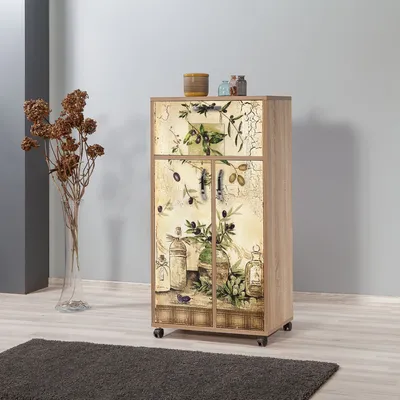 A tall, narrow cabinet with a decorative front, standing on a wooden floor in a room with gray walls. A dark rug is in the foreground, and a vase with dried flowers is to the left.