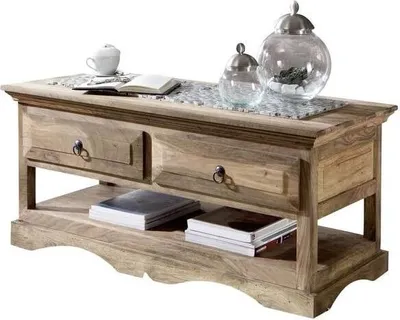 A wooden coffee table with drawers and a lower shelf, decorated with books and glass jars.