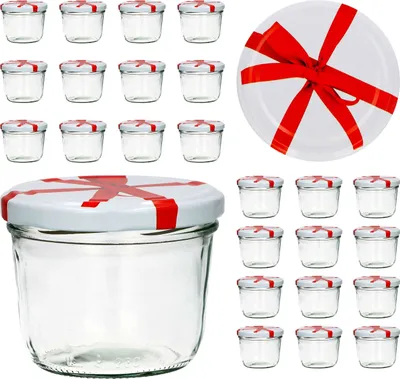 A collection of small glass jars with white lids decorated with red ribbon-like patterns, arranged on a white background. One jar is in the foreground, larger and more detailed, while others are arranged in rows behind it. A white plate with a red ribbon i