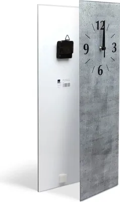 A tall, rectangular clock with a concrete-like face and black hands is shown from a slightly angled side view. The back of the clock, with its mechanism, is visible on the left.