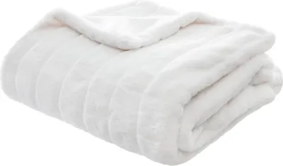 A folded white faux fur blanket.