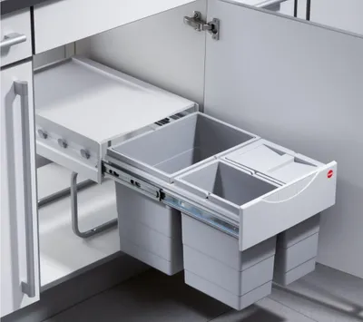 A pull-out waste bin system installed in a kitchen cabinet.