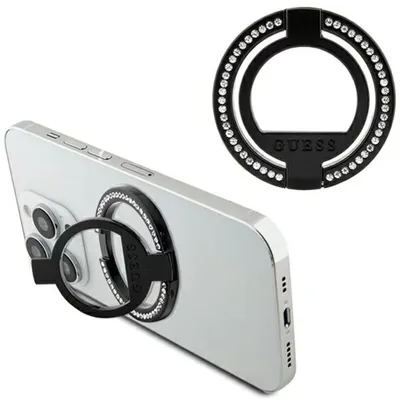 A black ring stand with rhinestones, branded with 'GUESS', is shown attached to the back of a silver smartphone. A separate, close-up view of the ring stand is also present.