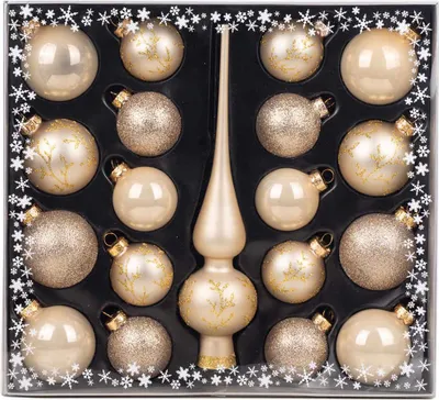A set of champagne-colored Christmas ornaments and a tree topper, arranged in a black box with snowflake decorations on the border.