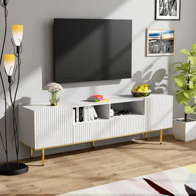 A modern living room scene featuring a white TV stand with a television mounted above it, a floor lamp, and decorative items.