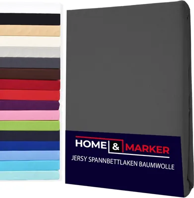 Dark gray jersey fitted sheet next to a stack of fabric swatches in various colors