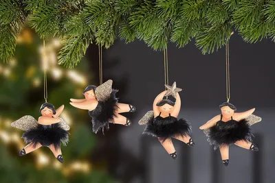 Four angel ornaments hanging from a Christmas tree branch.