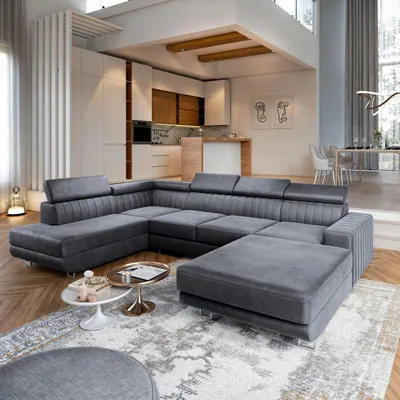 A spacious, modern living room and kitchen area with a large sectional sofa in the foreground.