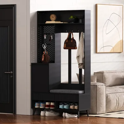A modern entryway with a black hall tree, shoe bench, and coat rack, next to a door and a sofa.