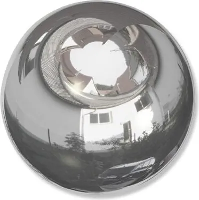 A highly reflective spherical object, likely a decorative end cap for a curtain rod, showing distorted reflections of a house and its surroundings.