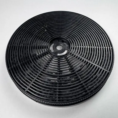 A close-up overhead shot of a black circular charcoal filter for a range hood.