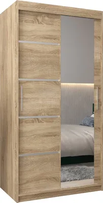 A wooden wardrobe with sliding doors and a mirror, reflecting a bedroom interior.