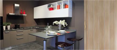 A modern kitchen with cabinets, a stove, a range hood, and a small island with stools.