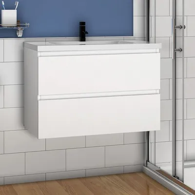 A white bathroom vanity with a black faucet against a blue wall and white tiled backsplash.