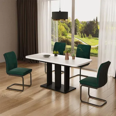 A dining table with chairs set in a room with a large window overlooking a garden.
