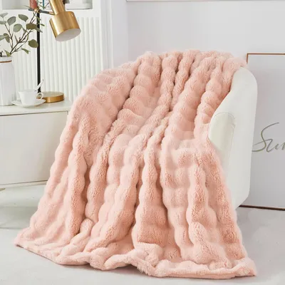 A pink plush blanket draped over a white armchair.