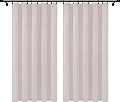 Two cream-colored velour curtains hanging on a black curtain rod against a white background.