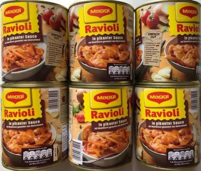 A stack of four cans of Maggi Ravioli in pikanter Sauce.
