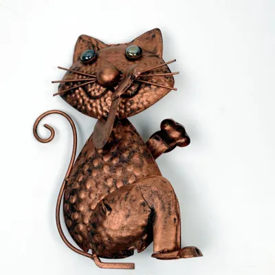 A copper-look metal cat figurine is shown against a white background.