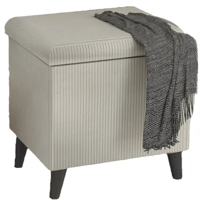 A beige storage ottoman with a gray blanket draped over it, shown on a white background.