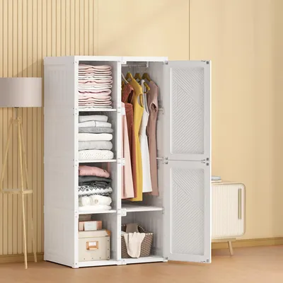 A white plastic wardrobe with clothes and folded items inside, set against a yellow striped wall.