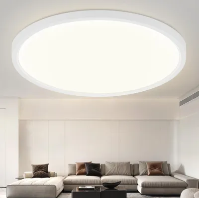 A modern living room with a sectional sofa and a large, round ceiling light.