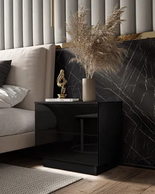 A modern bedroom setting with a bedside table, bed, and decorative elements.